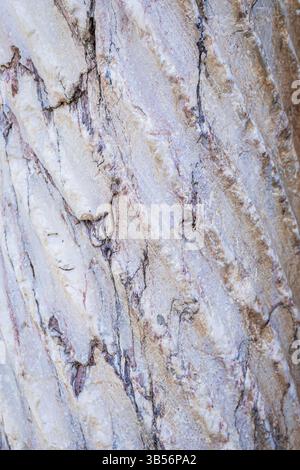 Nahaufnahme einer Marmorfelsoberfläche mit komplizierten natürlichen Adern und Farbvariationen. Das Bild erfasst die Rohtextur und die Mineralmuster in s Stockfoto