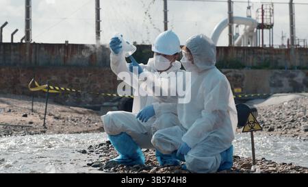 Ökologe, der Wasser giftiger Chemikalien vom Flusspalast auf einem digitalen Tablet entnimmt Stockfoto