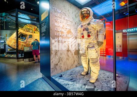 Smithsonian National Museum of Air and Space on National Mall Washington DC | WASHINGTON D.C., Vereinigte Staaten – Neil Armstrongs A7L-Raumanzug steht in der „Destination Moon“-Galerie des National Air and Space Museum, wobei das verbrannte Apollo 11-Kommandomodul Columbia hinter Glas sichtbar ist. Armstrong trug diesen Anzug während des ersten Mondgangs am 20. Juli 1969. 2019 wurde es wieder ausgestellt, nachdem die Schutzarbeiten zum 50. Jahrestag der Mission geplant waren. Stockfoto