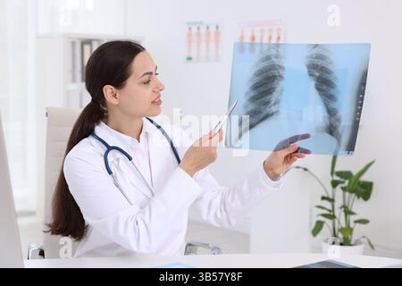 Arzt untersucht MRT-Scan am Schreibtisch im Krankenhaus Stockfoto