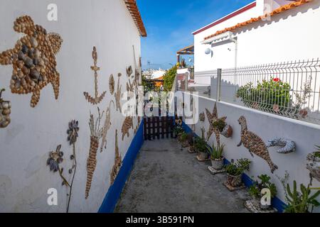 Nahaufnahme einer Sammlung von Kunstwerken, die mit Muscheln auf einem Haus verkrustet sind. Stockfoto