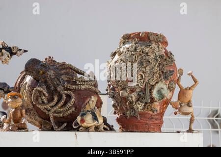 Nahaufnahme einer Sammlung von Vasen und Objekten, die mit Muscheln verkrustet sind. Stockfoto