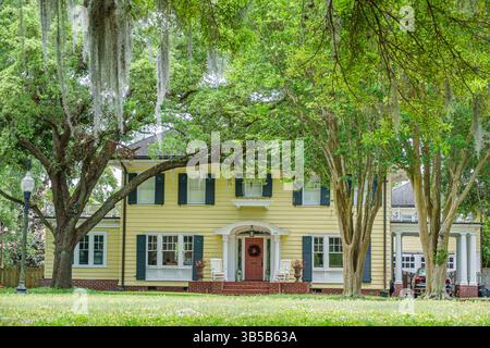 Orlando Florida, College Park, Ivanhoe Plaza Park, Kolonialhaus im Revival Stil, gelbes zweistöckiges Haus, schwarze Fensterläden, weiße Verkleidung, Backsteintreppen, rote Fassade Stockfoto