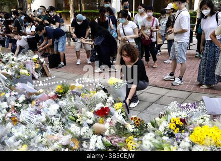 12. September 2022, HONGKONG, CHINA: Eine Frau aus Hongkong legt einen Blumenstrauß auf den Gehweg vor dem britischen Generalkonsulat Hongkong, um der verstorbenen Königin Elisabeth II. Respekt zu zollen. Hongkong ehrt weiterhin die verstorbene britische Königin, die ihre tiefen emotionalen Beziehungen zur britischen Monarchie als Bürger der ehemaligen Kronkolonie zum Ausdruck bringt.Sept-12.2022Hong Kong.ZUMA/Liau Chung-ren (Kreditbild: © Liau Chung-ren/ZUMA-ren/ZUMA Press Wire) Stockfoto