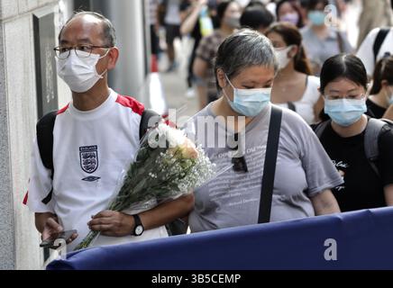 12. September 2022, HONGKONG, CHINA: Ein Mann aus Hongkong in Uniform der englischen Fußballnationalmannschaft hält einen Blumenstrauß und wartet darauf, in das britische Generalkonsulat Hongkong einzutreten, um der verstorbenen Königin Elizabeth II. September 2022 Respekt zu zollen.Hongkong.ZUMA/Liau Chung-ren (Kreditbild: © Liau Chung-ren/ZUMA Press Wire) Stockfoto