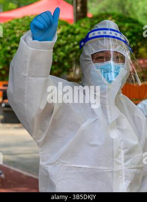 12. April 2022, Shanghai, China: Ein medizinisches Personal im Royal Sunny Bay Apartmentkomplex gibt während eines stadtweiten Coronavirus-Tests einen Daumen nach oben. Am 12. April wurden in Shanghai Massentests durchgeführt, bei denen alle Bürger einen covid-Test durchführen mussten. Die Stadt hat 26,4 Millionen Einwohner. (Kreditbild: © Mark Lent/ZUMA Press Wire Service) Stockfoto