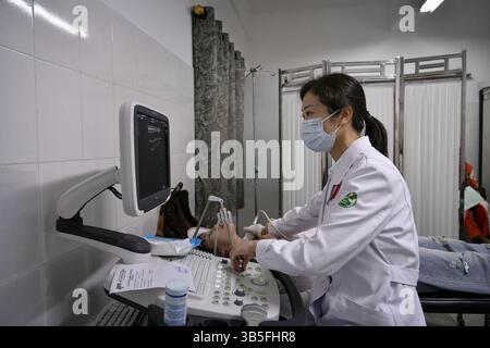 Conakry, Guinea. April 2025. Der chinesische Arzt Zhao Jing untersucht am 29. April 2025 im Chinesisch-Guinean Friendship Hospital in Conakry, Guinea, einen Patienten mittels Ultraschall. Das 31. Chinesische Ärzteteam, das nach Guinea entsandt wurde, kam im März 2025 in das Land an und hat medizinische Dienstleistungen für lokale Patienten und Schulungen für örtliche Ärzte bereitgestellt. Quelle: Han Xu/Xinhua/Alamy Live News Stockfoto