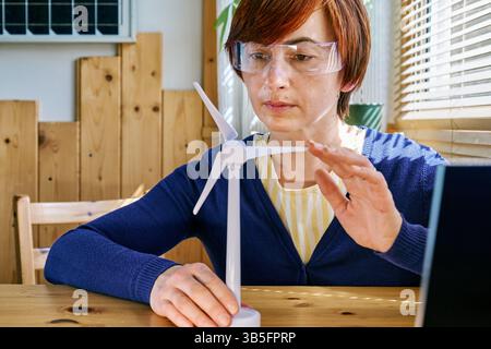 Geschäftsfrau mit Augmented-Reality-Brille Analyse Windturbinenmodell im Heimbüro in der Erneuerbare-Energien-Industrie. Stockfoto