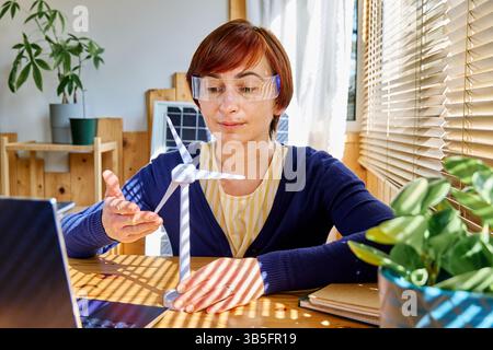 Geschäftsfrau mit Augmented-Reality-Brille Analyse Windturbinenmodell im Heimbüro in der Erneuerbare-Energien-Industrie. Stockfoto