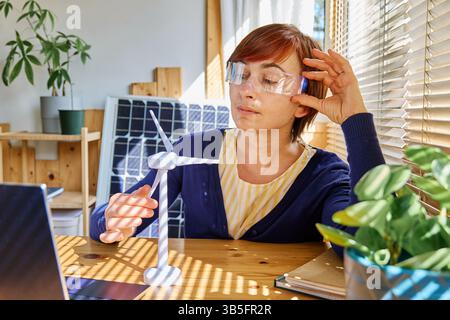 Geschäftsfrau mit Augmented-Reality-Brille Analyse Windturbinenmodell im Heimbüro in der Erneuerbare-Energien-Industrie. Stockfoto