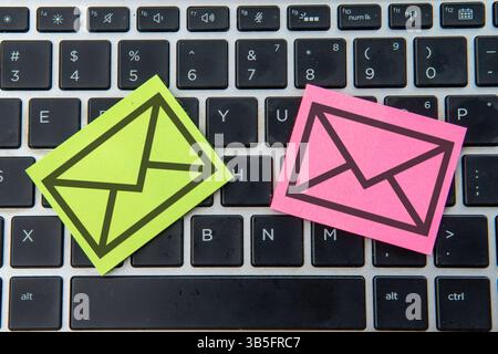 Die Haftnotiz mit schwarzer Umrandung eines Umschlags auf einer Laptop-Tastatur. E-Mail- und Kommunikationskonzept. Stockfoto