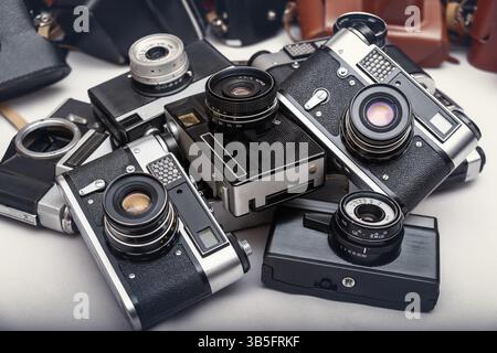 Ein vielfältiges Sortiment alter Filmkameras, die zusammen gezeigt werden und ihre einzigartigen Designs und komplizierten Mechanismen hervorheben, die die Fotografie geprägt haben. Stockfoto