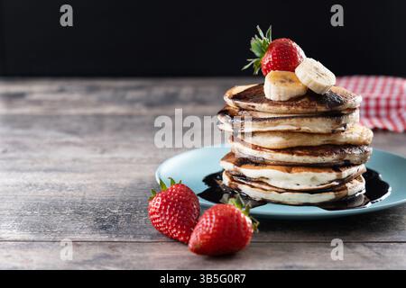 Pfannkuchen mit Schokolade und Obst auf Holztisch Stockfoto