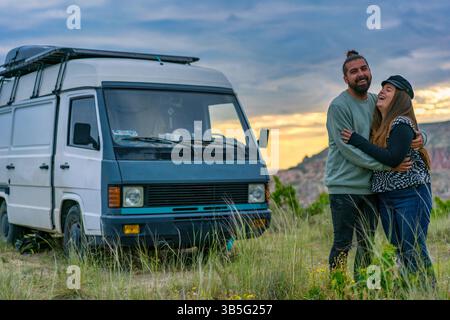 Ein Paar umarmt und lacht vor dem Wohnmobil in Kappadokien Stockfoto
