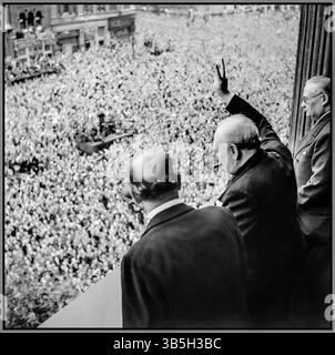 Der Premierminister Winston Churchill weht vor den ekstatischen Menschenmassen in Whitehall London den V-Sieg, während sie den VE Day am 8. Mai 1945 feiern. „Sieg in Europa“ vom Londoner Balkon des Gesundheitsministeriums überreicht Premierminister Winston Churchill mit seiner Markenzigarre sein berühmtes „V for Victory“-Zeichen an die massenhaften Menschenmassen in Whitehall am selben Tag, an dem er der britischen Nation den Sieg gegen Nazi-Deutschland übermittelte, am 8. Mai 1945 (VE Day). Zu Churchills Linker gehört Sir John Anderson, der Finanzminister. Zu Churchills Rechten ist Ernest Bevin, der Arbeitsminister. 8. Mai 1945 Stockfoto