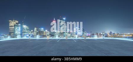 Leerer Parkplatz mit EV-Ladestationen und perth City Skyline in der Nacht. 3D-Rendering Stockfoto