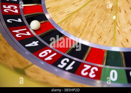 Roulette-Tisch im Kasino. Ball in der rotierenden Spielmaschine. Roulette-Rad aus Holz Stockfoto