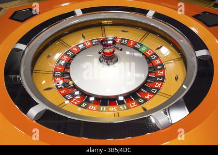 Roulette-Tisch im Kasino. Ball in der rotierenden Spielmaschine. Roulette-Rad aus Holz Stockfoto