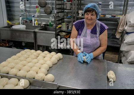 5. September 2022, Charkiw, Ukraine: Ein Freiwilliger bereitet in einer von Myrne Nebo betriebenen Anlage, die am 5. September 2022 in Charkiw, Ukraine, Backwaren für die vom Krieg betroffenen Menschen vor. Die gemeinnützige Organisation bietet kostenlose Mahlzeiten in der Stadt Charkiw sowie gelieferte Mahlzeiten und unverderbliche Güter für Dörfer nahe der Front des Russland-Ukraine-Krieges in der Region Charkiw an. (Bild: © David Ryder/ZUMA Press Wire) Stockfoto