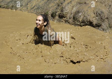 Sofia, Bulgarien - 9. Juli 2016: Ein Teilnehmer springt beim Legion Run Extremsport Challenge in der Nähe von Sofia ins matschige Wasser. Die Sportveranstaltung ist mu Stockfoto