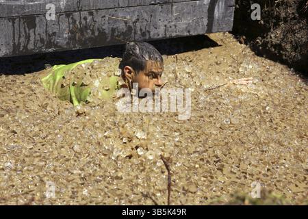 Sofia, Bulgarien - 9. Juli 2016: Ein Teilnehmer taucht im Eiswasser bei der extremen Sportwettbewerb Legion Run in der Nähe von Sofia. Das Sportereignis ist Schlamm Stockfoto