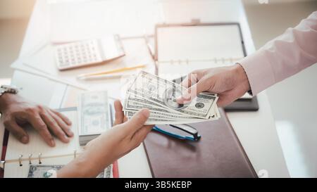 Ein Mann, der Hundert Dollar-Scheine anbietet. Hand eines Geschäftsmannes, der seinem Partner Geld gibt. Hand erhält Geld vom Geschäftsmann. Bestechung, Bestechung, Stockfoto