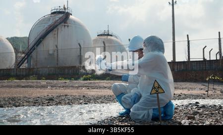 Ökologe, der Wasser giftiger Chemikalien vom Flusspalast auf einem digitalen Tablet entnimmt Stockfoto