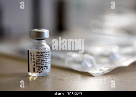 Sofia, Bulgarien - 20. Januar 2021: Eine Durchstechflasche mit dem Pfizer-BioNTech-Impfstoff gegen COVID-19 neben Injektionen Stockfoto
