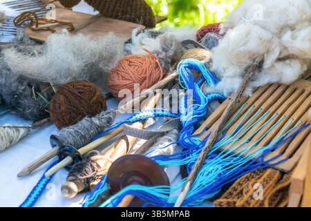 Wolle und Garn mit Webwerkzeugen auf dem Tisch. Stockfoto