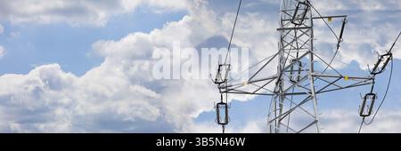 Ein hoher Stab zur Übertragung von Elektrizität durch die Luft über hängende Drähte. Blauer Himmel mit wehenden weißen Wolken Stockfoto