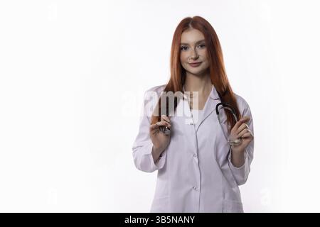 Eine selbstbewusste junge Ärztin, die einen Labormantel mit Stethoskop trägt, ist vollständig vorbereitet und bereit, Patienten zu helfen Stockfoto