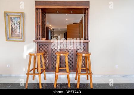 Ein Bild von einer Bar im Innenbereich mit Holzhockern in einem luxuriösen mediterranen Haus Stockfoto