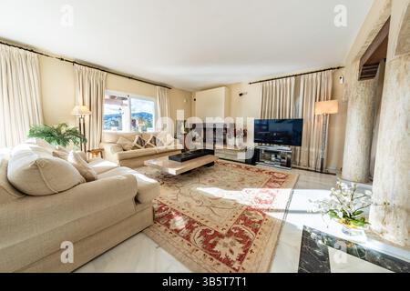 Ein Bild eines großen Wohnzimmers mit Steinsäulen in einem mediterranen Ferienhaus Stockfoto