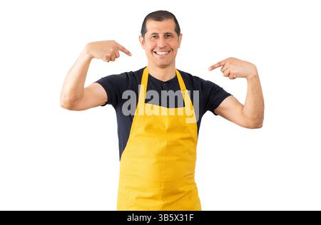 Verkäufer mit gelber Schürze über weißem isoliertem Hintergrund, der selbstbewusst mit einem Lächeln auf dem Gesicht aussieht und sich mit den Fingern stolz und glücklich zeigt. Stockfoto