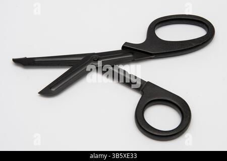 Schwarze medizinische Schere mit stumpfem Ende auf weißem Hintergrund - ein professionelles Notfallwerkzeug Stockfoto