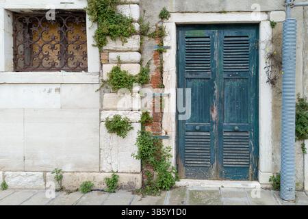 Holztür in Vintage Blue mit Fenstergitter aus Ivy und Iron Stockfoto