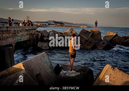 29. Mai 2022, Barcelona, Spanien: Männer fischen bei Sonnenuntergang aus einem Wellenbrecher in Barcelona. (Bild: © Jordi Boixareu/ZUMA Press Wire) Stockfoto