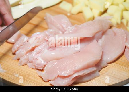 Zubereitung frischer Hähnchenfilets auf einem hölzernen Schneidebrett Stockfoto