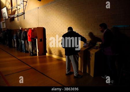 Ein Wähler legt seine Stimmzettel am Wahltag der australischen Bundestagswahlen 2025 in eine Wahlbox in einem Wahlzentrum. Der Tag der australischen Bundestagswahlen 2025 beginnt heute, am 3. Mai, und die Wähler gehen zu Wahllokalen im ganzen Land, um ihre Stimmen abzugeben. Das Werribee Secondary College dient als ein solches Zentrum in der Division of Lalor, einem Safe Labor Seat, der von der Parlamentsabgeordneten Joanne Ryan gehalten wird. Die Wähler stehen vor ständigen Herausforderungen in Bezug auf Infrastruktur, Wohnraum und Verkehr. Die Kandidatin der Liberalen Partei Mira D'Silva bestritt den Sitz und versucht, die seit langem bestehende Vorherrschaft der Labour Party in der Region herauszufordern. Stockfoto
