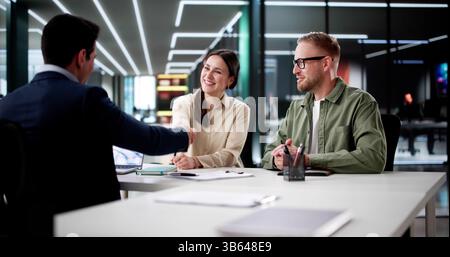 Ein Junges Paar Trifft Sich Mit Einem Darlehensvermittler, Um Eine Finanzvereinbarung Zu Unterzeichnen. Stockfoto