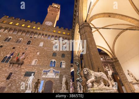 FLORENZ, ITALIEN - 17. MÄRZ 2025: Die Loggia dei Lanzi und der Palazzo Vecchio in der Abenddämmerung. Stockfoto