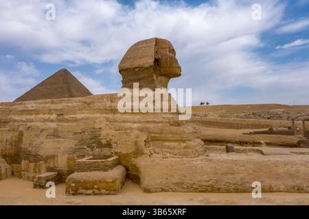 Die große Sphinx von Gizeh, Ägypten, vor der zweitgrößten Pyramide auf dem Plateau, der Chephren-Pyramide mit Kamelreitern Stockfoto
