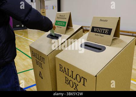 Ein Wähler legt seine Stimmzettel am Wahltag während der australischen Bundestagswahl in eine Wahlbox in einem Wahlzentrum. Am Wahltag des 3. Mai 2025 gaben die Wähler der Division of Hotham ihre Stimmzettel an Wahllokalen ab, darunter am Killester College in Springvale. Der Sitz des Labour-Abgeordneten Clare O'Neil seit 2013 wird von dem liberalen Kandidaten Harmick Singh Matharu, dem Grünen-Kandidaten Martin Barry und anderen umstritten. Zu den zentralen Themen der Wähler zählen der Druck auf die Lebenshaltungskosten, die Erschwinglichkeit des Wohnraums und die Entwicklung der Infrastruktur. Hotham umfasst eine vielfältige, multikulturelle Bevölkerung im Südosten und im Südosten Stockfoto