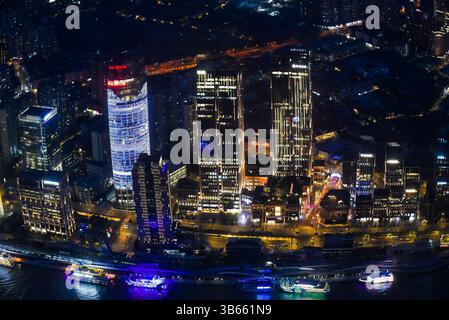 Shanghai, China - 1. April 2025: Die neonbeleuchtete Skyline von Pudong reflektiert den Huangpu River bei Nacht und zeigt moderne Wolkenkratzer und urbane Lebendigkeit Stockfoto