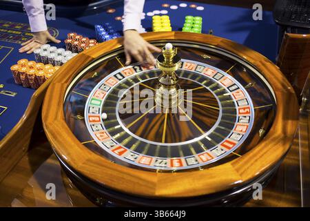 Roulette-Tisch im Kasino. Ball in der rotierenden Spielmaschine. Roulette-Rad aus Holz. Casino Croupier veröffentlicht Roulette White Ball Stockfoto