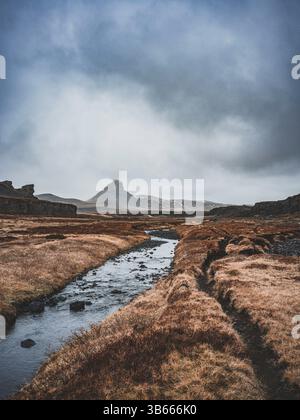 Winding stream through barren Icelandic highlands under a moody sky on Emstruleið trail Stockfoto