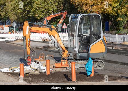 Kleiner Bagger auf einer Straßenbaustelle Stockfoto