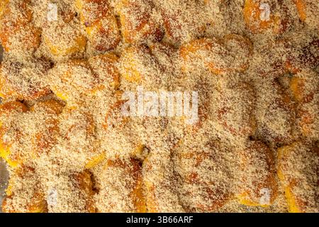 Das Streuen von geriebenen Nüssen auf sfintisori. Rumänische Küche. Hausgemachte Mucenici, traditionelle Desserts in der Abbildung 8, mit Honig bestrichen Stockfoto
