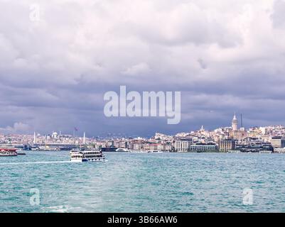 Blick auf die Stadt Istanbul mit Booten auf dem Bosporus unter bewölktem Himmel Stockfoto
