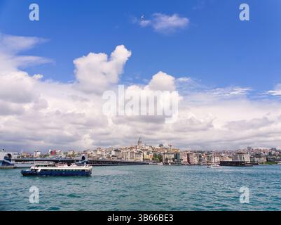 Istanbul, Türkei - 3. Mai 2024: Blick auf die Stadt Istanbul mit Galatenturm, Schiffen auf der Bosporus-Meerenge und flauschigen Wolken am Himmel Stockfoto